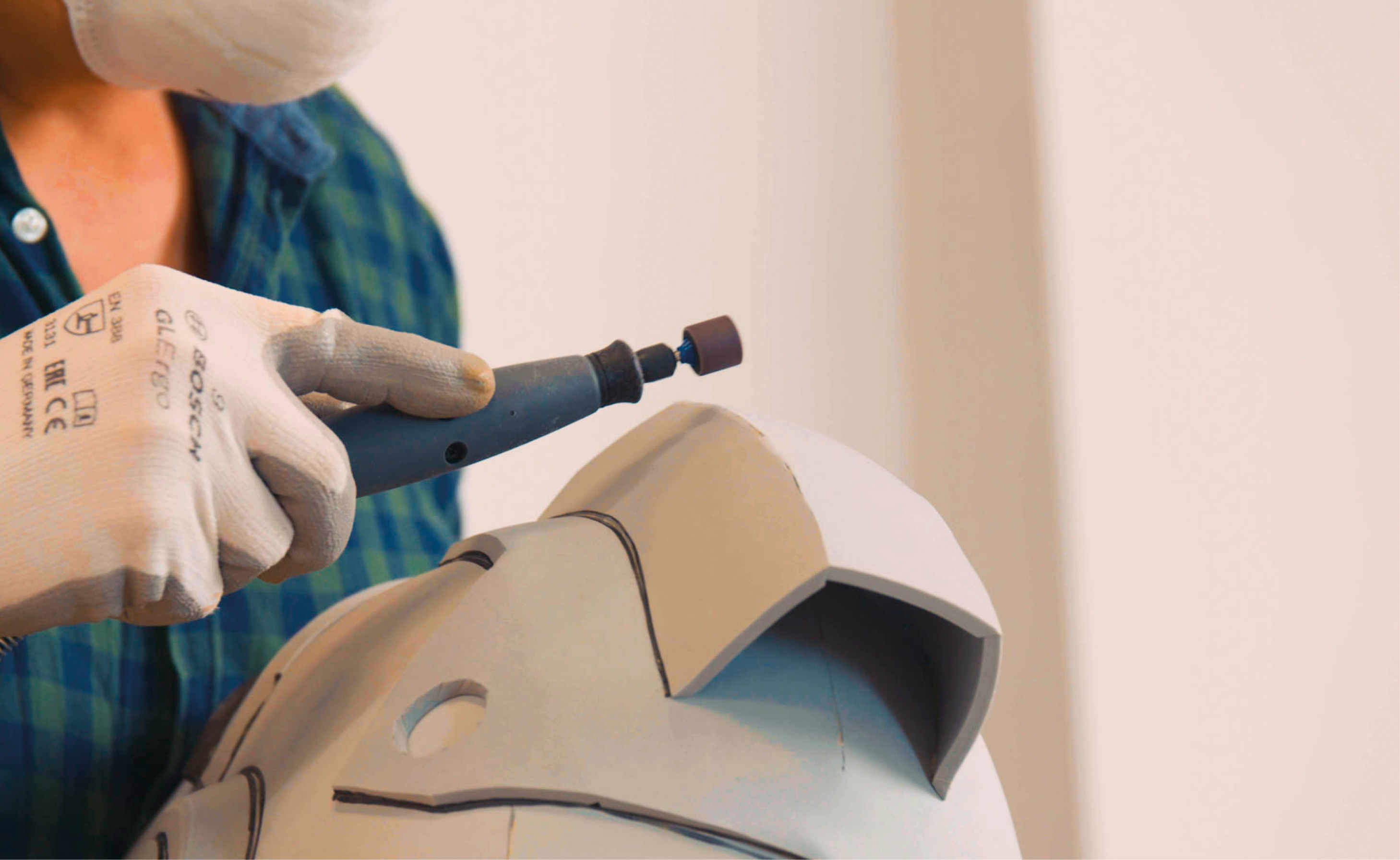 Biztonsági felszerelésben a Flexibilis szár és a Flex-Shaft szerszámtartó segítségével csiszold le az EVA habból készült cosplay sisak széleit a Dremel 8220 szerszámmal és csiszolótartozékaival.